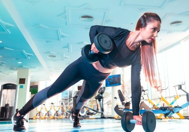 Jeune femme pendant un cours de body pump à la salle de sport