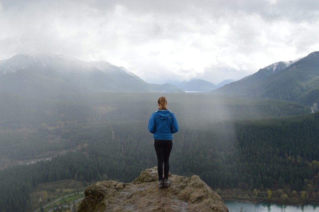 photo de dos d'une personne en haut d'un sommet